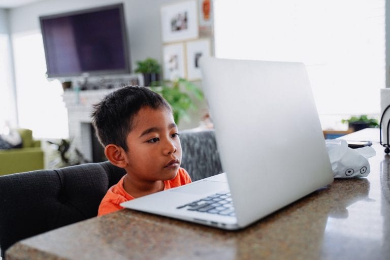Diverse young little boy inside house home school
