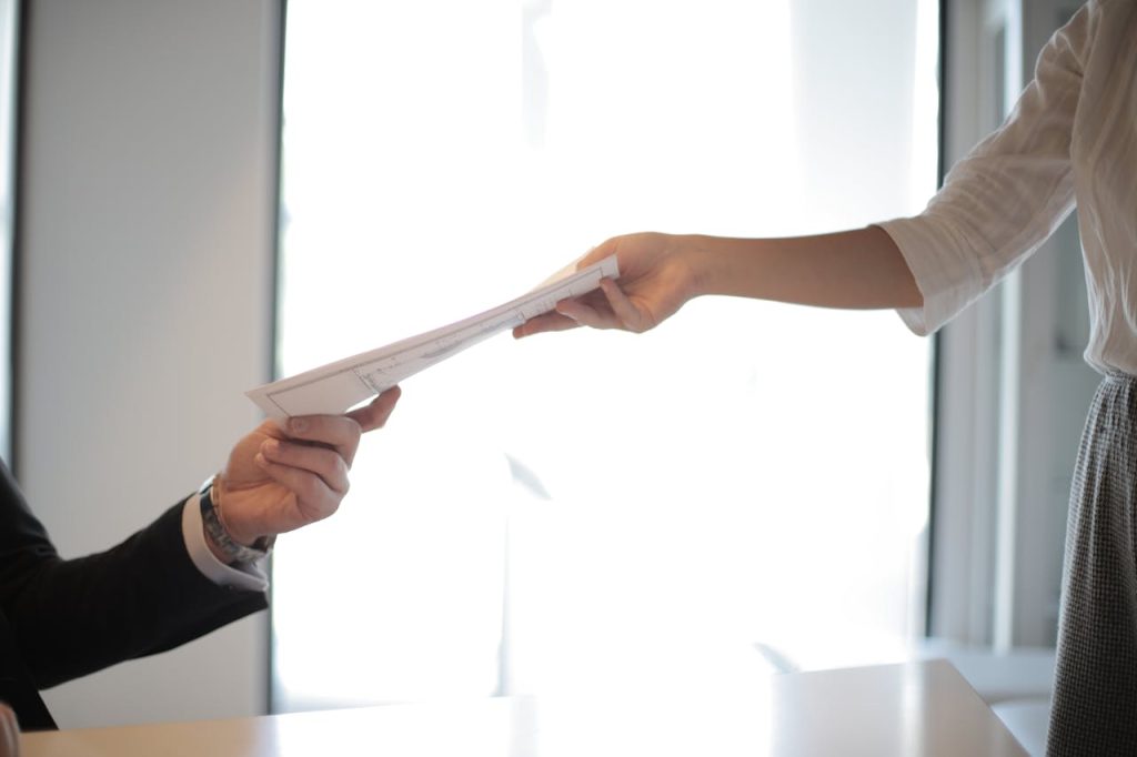A person handing over their resume